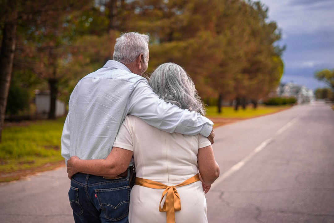 Two older adults walking arm in arm